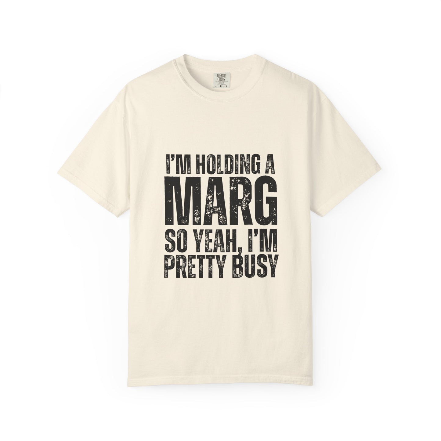 Beige t-shirt with black text reading 'I'm holding a marg so yeah, I'm pretty busy'