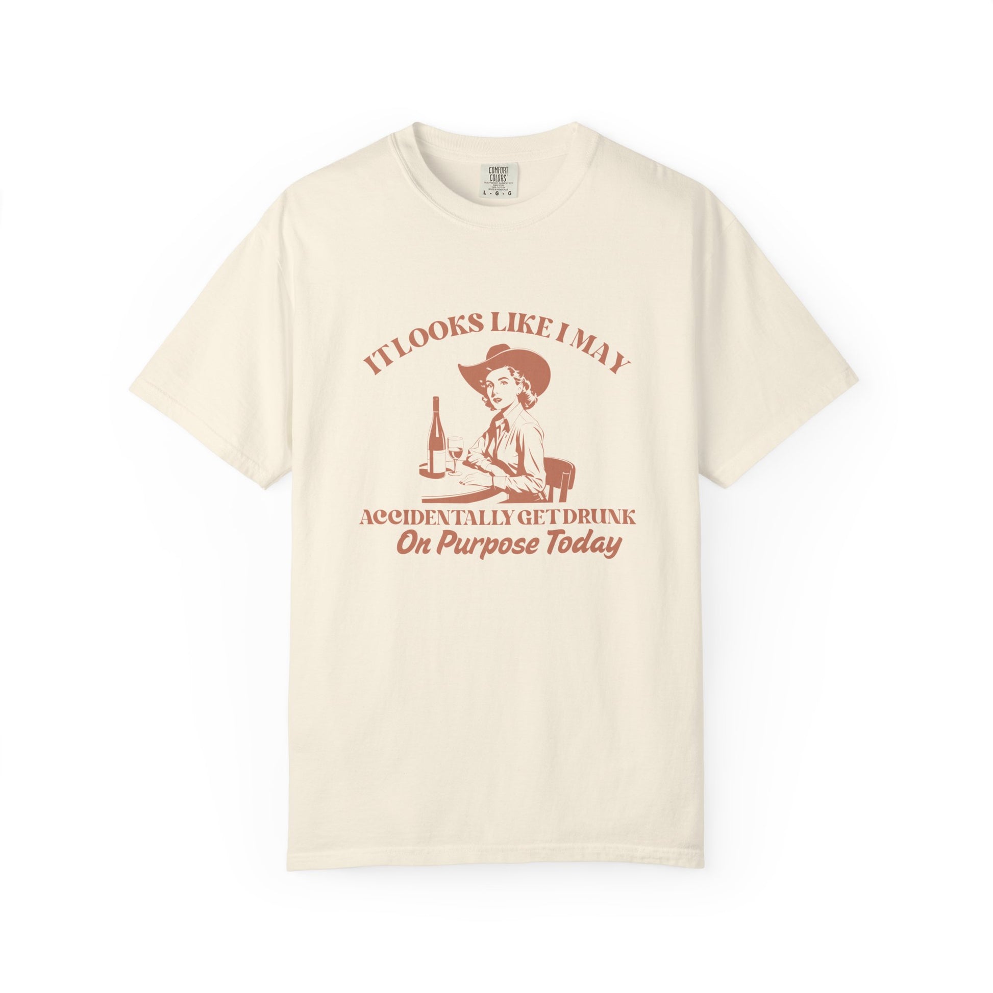 Beige shirt with a cowgirl and text that says 'It looks like I may accidentally get drunk on purpose today' 
