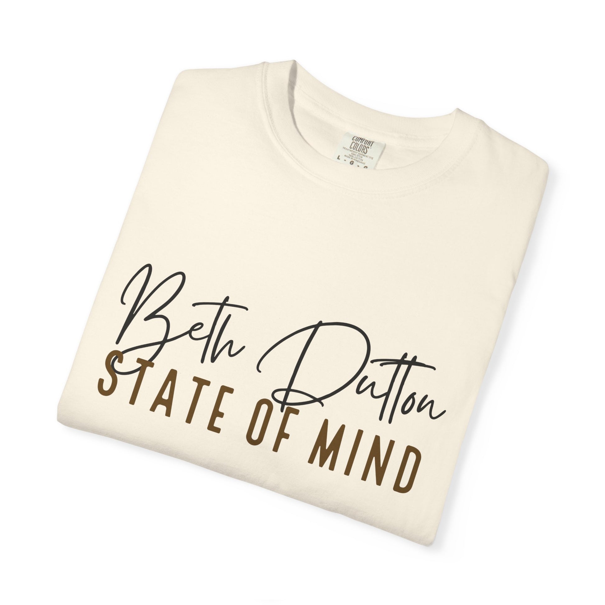 Folded cream-colored t-shirt with 'Beth Dutton State of Mind' text on a white background