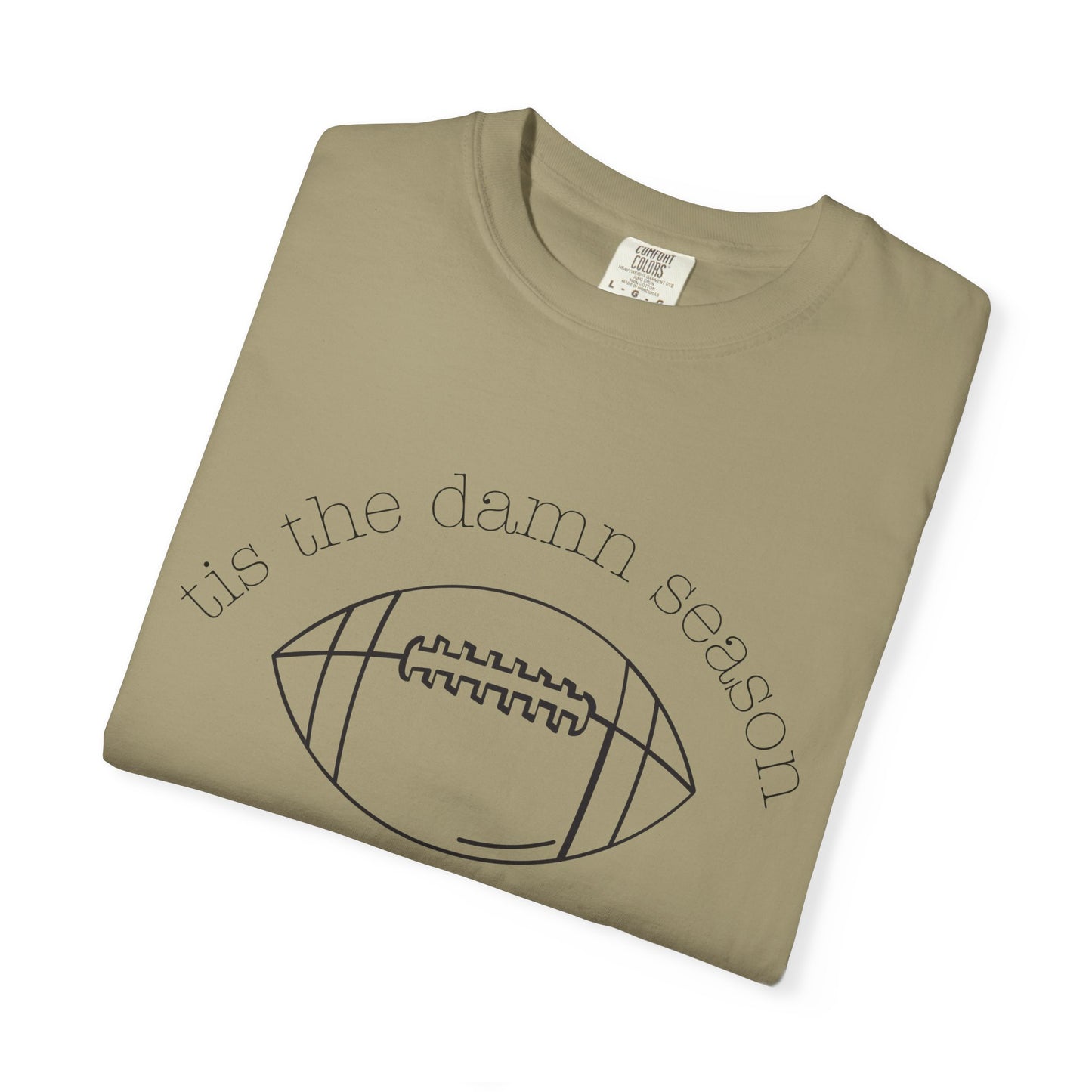 Folded khaki t-shirt with 'tis the damn season and football graphic on a white background