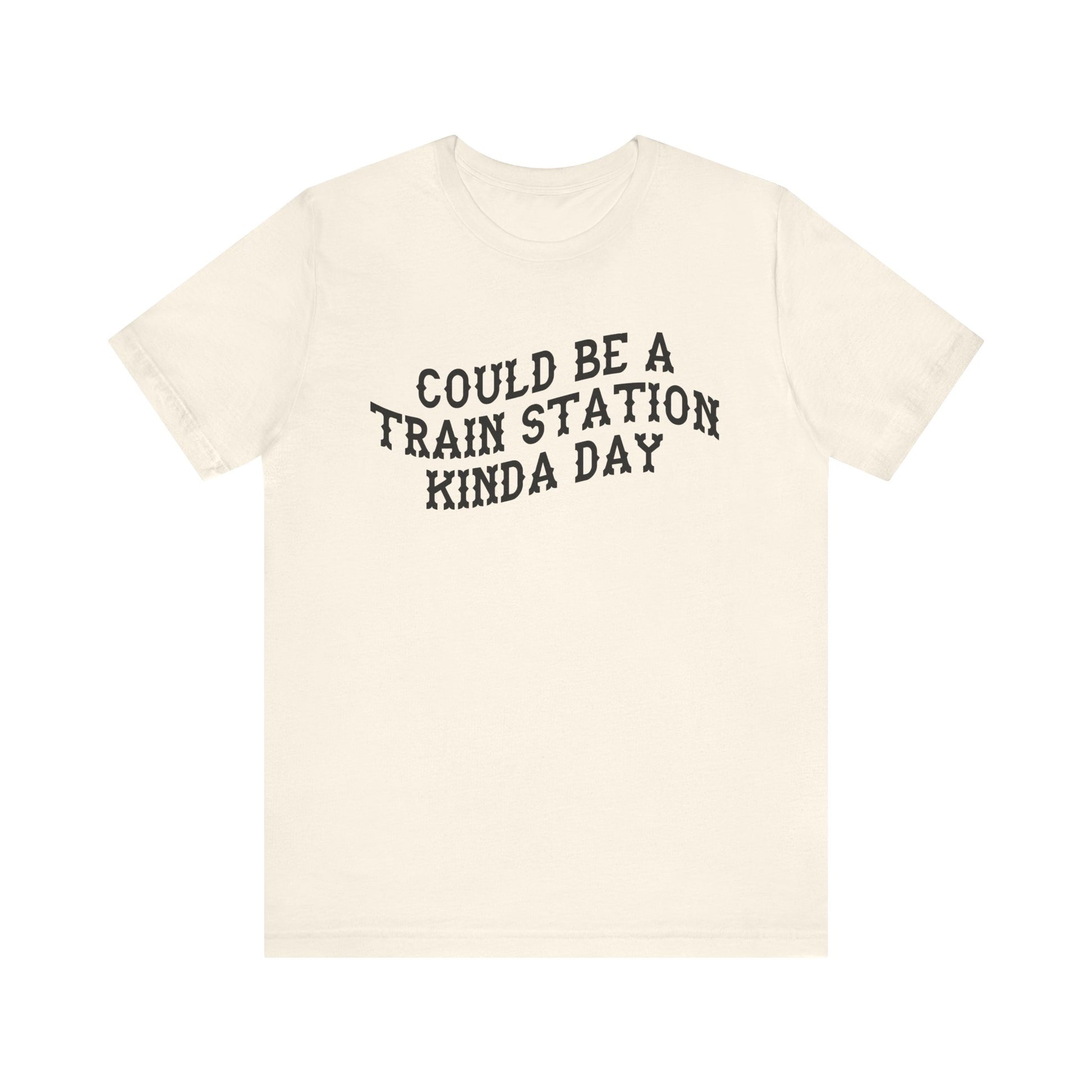Beige t-shirt with 'could be a train station kinda day' in black text on a white background
