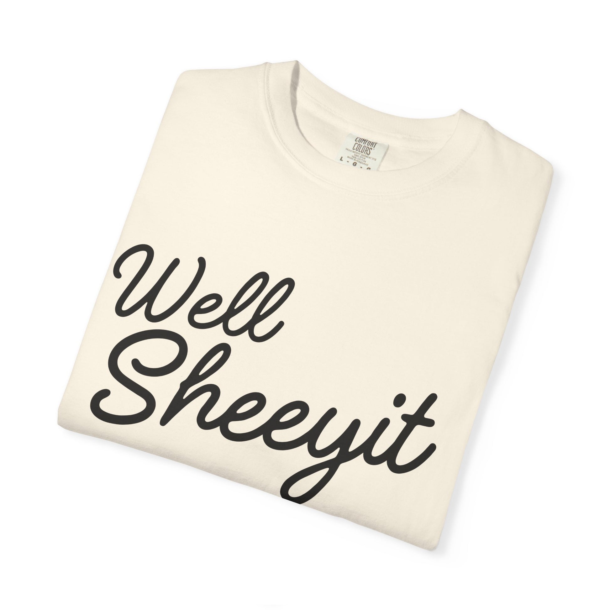 Beige folded shirt with 'well sheeyit' in text